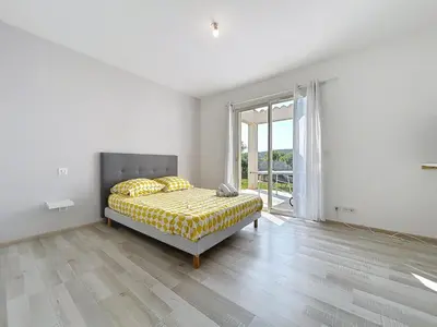 a white bedroom with a bed and a large window at Villa Grivia - Maison avec grand jardin - Piscine - Pétanque - Ping Pong in Saint-André-de-Roquelongue