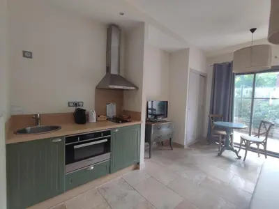 a kitchen with green cabinets and a sink and a table at La Redorte 14 in La Redorte