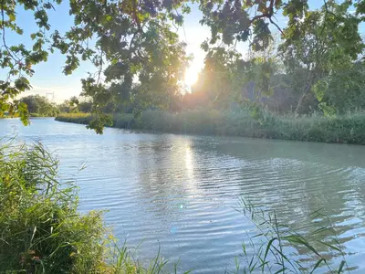 a river with the sun reflecting on the water at La Redorte 14 in La Redorte