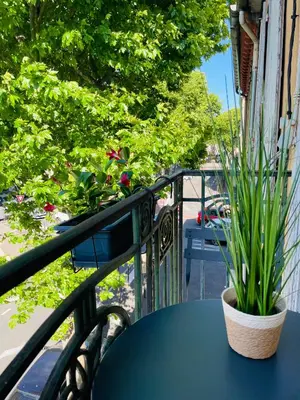 a blue table with a potted plant on a balcony at T3 Lumineux & Cosy avec Balcon Escapade by DarBonne in Narbonne