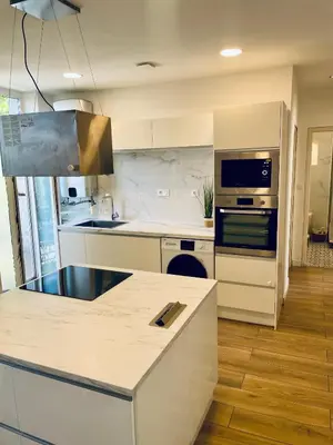 a kitchen with white counters and a stove top oven at T3 Lumineux & Cosy avec Balcon Escapade by DarBonne in Narbonne