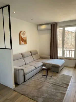 a living room with a couch and a table at T3 Lumineux & Cosy avec Balcon Escapade by DarBonne in Narbonne