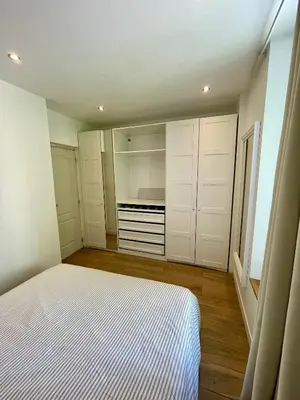 a bedroom with white cabinets and a bed in it at T3 Lumineux & Cosy avec Balcon Escapade by DarBonne in Narbonne