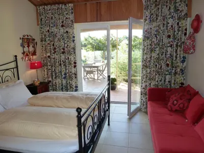 a bedroom with a bed and a couch and a patio at B&B Domaine Méditerranée in Paraza