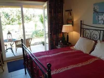 a bedroom with a bed and a sliding glass door at B&B Domaine Méditerranée in Paraza
