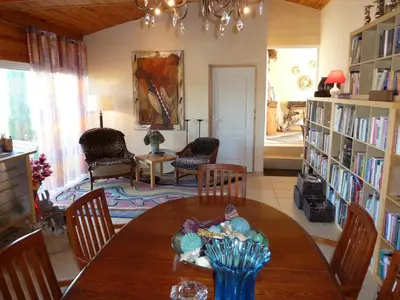 a living room with a table and chairs and bookshelves at B&B Domaine Méditerranée in Paraza