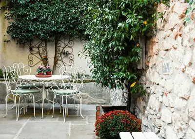 a table and chairs sitting next to a stone wall at Charming Riverside House In Medieval Village in Villeneuve-Minervois
