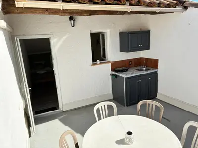 a kitchen with a table and a table and chairs at Gîte Molière in Sallèles-dʼAude