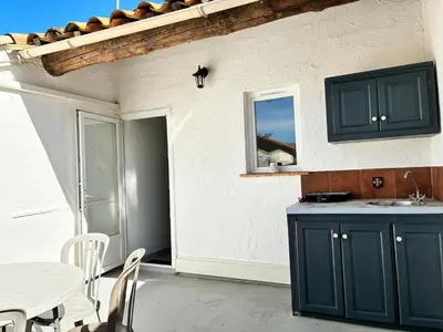 a kitchen with a sink and a table with chairs at Gîte Molière in Sallèles-dʼAude
