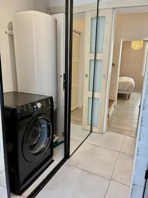 a washing machine in a room with a mirror at Gîte Molière in Sallèles-dʼAude