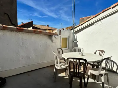 a patio with a table and chairs on a balcony at Gîte Molière in Sallèles-dʼAude