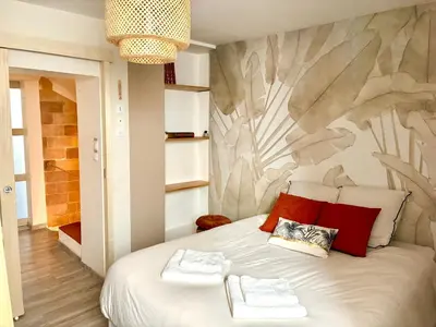 a bedroom with a large white bed with red pillows at Gîte Molière in Sallèles-dʼAude