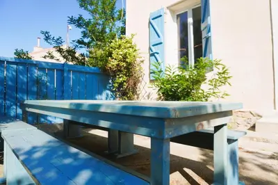 a blue bench sitting in front of a fence at La Maison du Saunier entre mer et garrigue in Lapalme