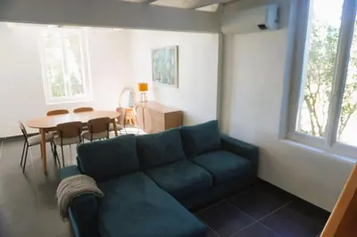 a living room with a blue couch and a table at La Maison du Saunier entre mer et garrigue in Lapalme