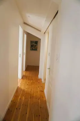 an empty hallway with wooden floors and white walls at La Maison du Saunier entre mer et garrigue in Lapalme