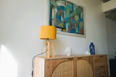 a lamp on top of a dresser with a painting at La Maison du Saunier entre mer et garrigue in Lapalme