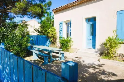 a blue picnic table in front of a house at La Maison du Saunier entre mer et garrigue in Lapalme