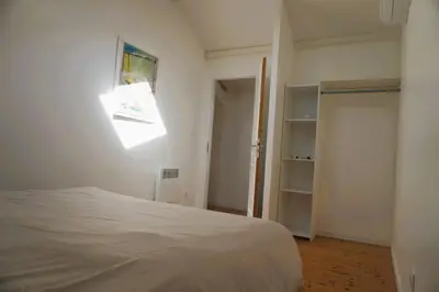 a bedroom with a bed and a window and a closet at La Maison du Saunier entre mer et garrigue in Lapalme