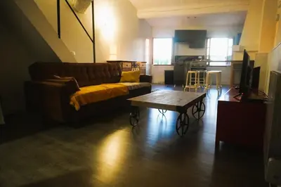 a living room with a wooden table and a television at Le Mirador St Just 3 people City in Narbonne