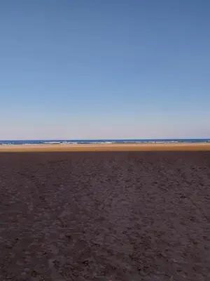 an empty beach with the ocean in the background at Appartement T2 lumineux à 200m de la plage, tout équipé in Port-la-Nouvelle