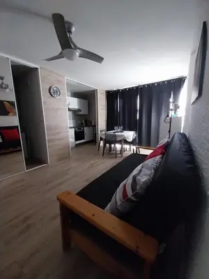 a bedroom with a bed and a living room at Appartement T2 lumineux à 200m de la plage, tout équipé in Port-la-Nouvelle