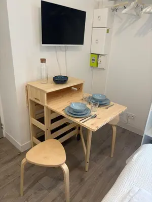 a small wooden table with a tv on a wall at Studio in Mirepoix