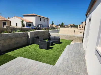 a small yard with chairs and grass at La Villa les Terrasses du Canal in Capestang