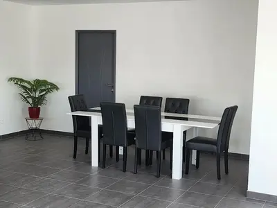 a dining room table with black chairs and a white table at La Villa les Terrasses du Canal in Capestang