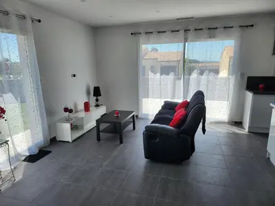 a living room with a black couch and red pillows at La Villa les Terrasses du Canal in Capestang