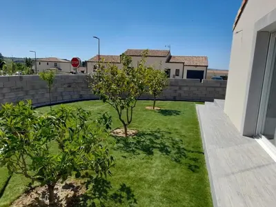 a yard with two trees and a stop sign at La Villa les Terrasses du Canal in Capestang