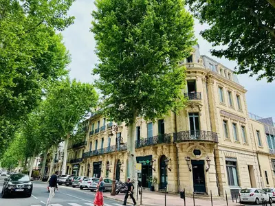 a building on a street with cars parked in front of it at Duplex T2 de haut-standing in Narbonne