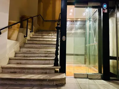 a set of stairs in a building with a glass door at Duplex T2 de haut-standing in Narbonne