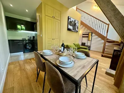 a dining room with a table with plates and wine glasses at Duplex T2 de haut-standing in Narbonne