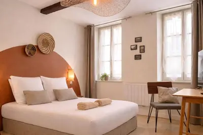 a bedroom with a large bed with two towels on it at Le Repaire Légendaire in Carcassonne