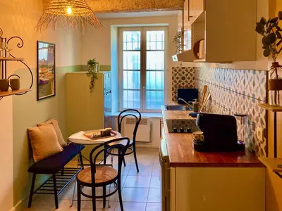 a kitchen with a counter and a table and chairs at Le Repaire Légendaire in Carcassonne