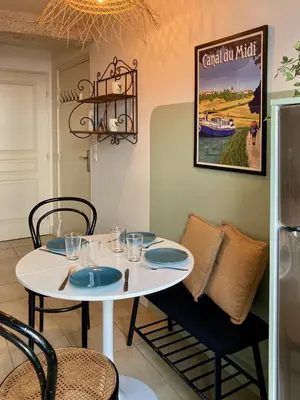 a white table and chairs in a room with a refrigerator at Le Repaire Légendaire in Carcassonne
