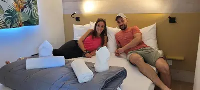 a man and a woman sitting on a bed at Studiotel premium 2 personnes in Pamiers