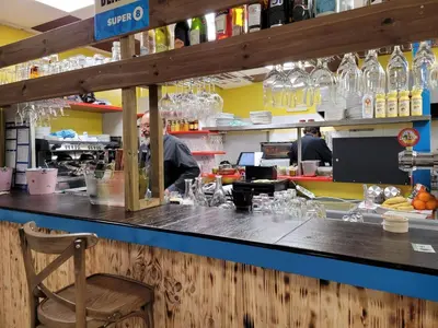 a counter in a restaurant with a man preparing food at Studiotel premium 2 personnes in Pamiers