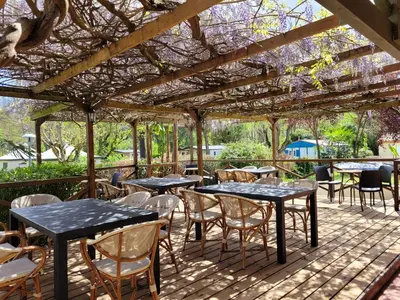 a patio with tables and chairs under a pergola at Studiotel premium 2 personnes in Pamiers