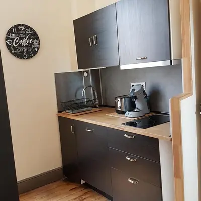a kitchen with black cabinets and a counter top at Gîte de la tour avec piscine entre Carcassonne et narbonne in Capendu