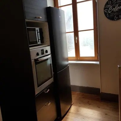 a refrigerator in a kitchen with a microwave and a window at Gîte de la tour avec piscine entre Carcassonne et narbonne in Capendu