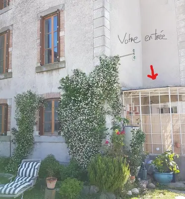 a ivy covered building with two chairs in a garden at Gîte de la tour avec piscine entre Carcassonne et narbonne in Capendu