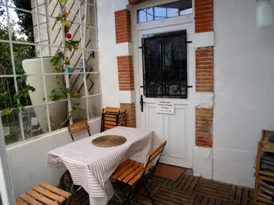 a table and chairs sitting in front of a door at Gîte de la tour avec piscine entre Carcassonne et narbonne in Capendu