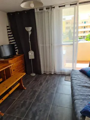 a living room with a couch and a window at Quatre Vent in Gruissan