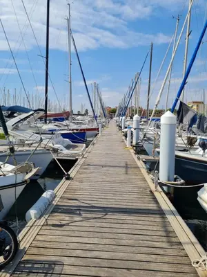 a wooden dock with many boats in a marina at Quatre Vent in Gruissan