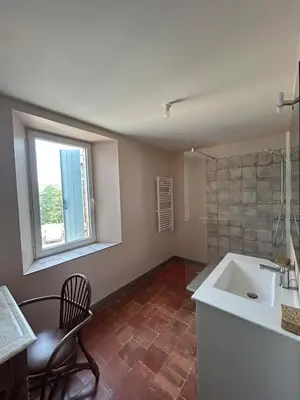 a bathroom with a sink and a chair and a window at Gîte de Montplo-Cruzy in Cruzy