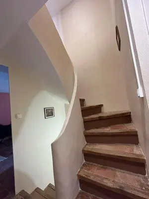a winding staircase in a home with wooden floors at Gîte de Montplo-Cruzy in Cruzy
