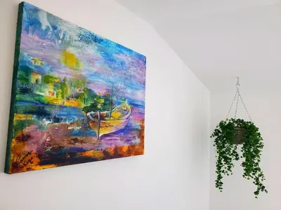 a painting hanging on a wall next to a plant at Renovated and air-conditioned 2-bedroom apartment with terrace in Saint-Paul-de-Fenouillet