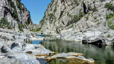 a river in a rocky canyon with rocks at Renovated and air-conditioned 2-bedroom apartment with terrace in Saint-Paul-de-Fenouillet