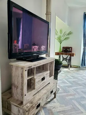 a tv sitting on top of a wooden dresser at Renovated and air-conditioned 2-bedroom apartment with terrace in Saint-Paul-de-Fenouillet